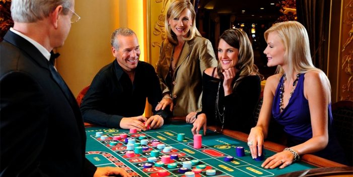 a group of people sitting around a casino table 