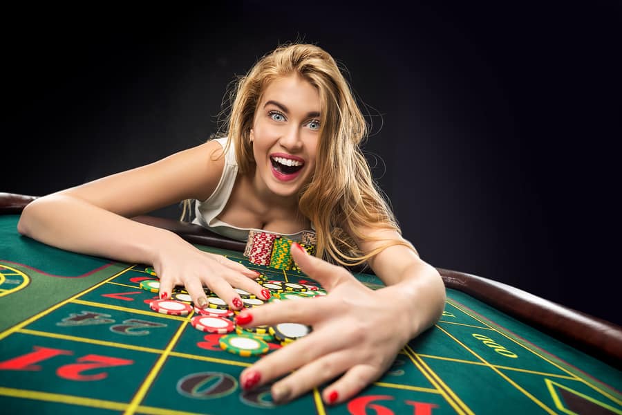 a woman getting her poker chips off the table 