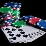 poker chips and casino cards on a black table