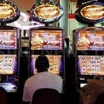 a group of people sitting in front of slot machines