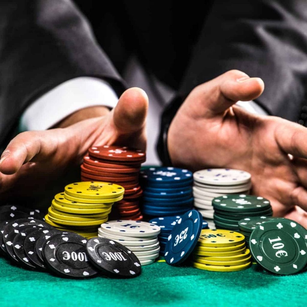 a man holding  poker chips in front of him 