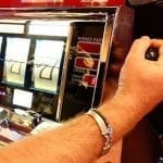 a hand pulling the handle of a slot machine